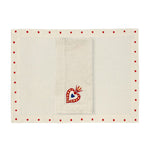 Set de Mantelería con  Individuales Silvia de lino arena con borde de puntos rojos y servilleta en lino arena con corazón milagrito bordado, marca Zash