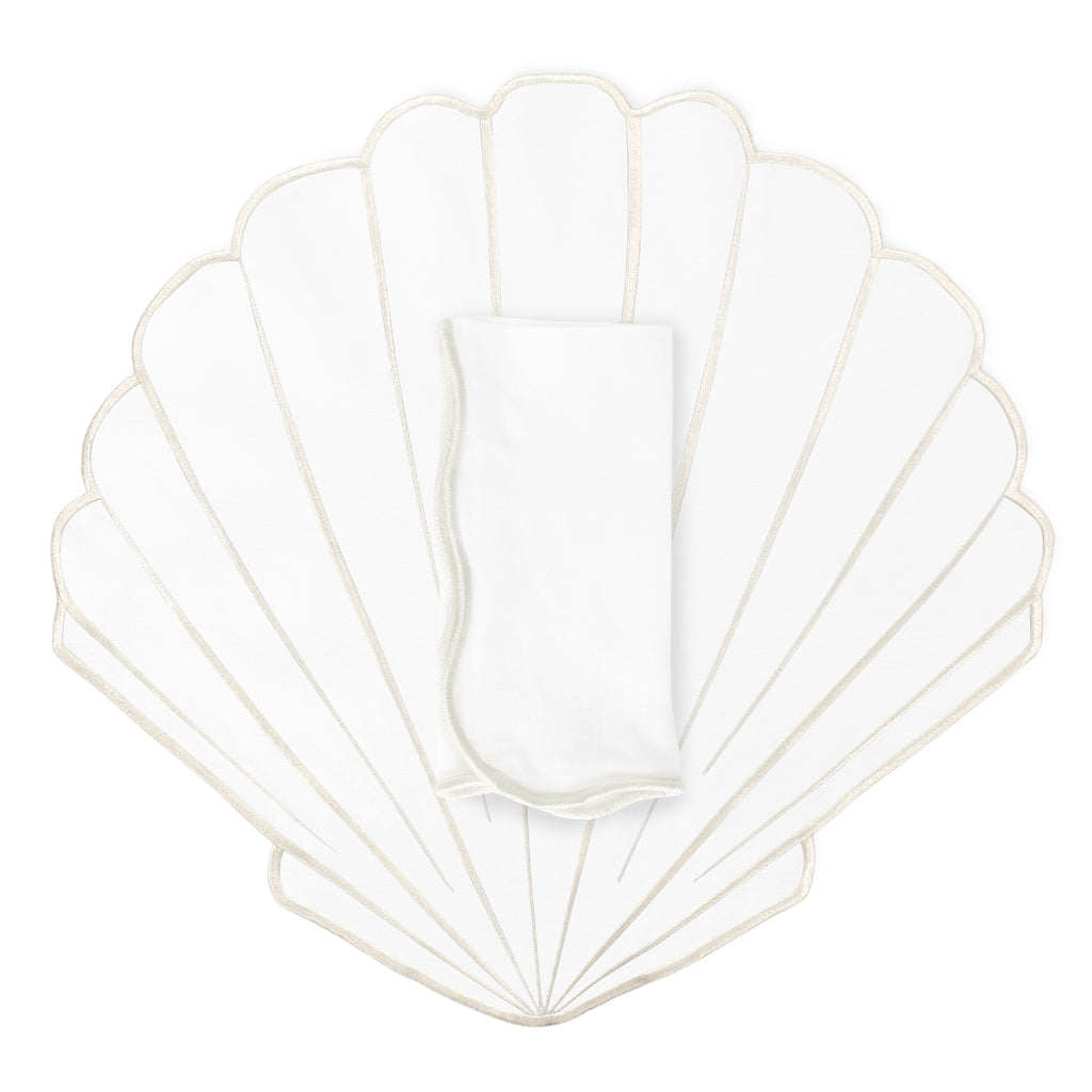 Set de mantelería con mantel individual en forma de concha blanca con orilla bordada ivory y servilleta de la marca Zash. Perfecta para mesas de playa 