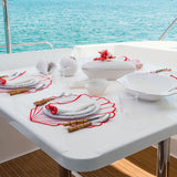 Set Mantelería Concha en Rojo: 4 Individuales en Forma de Concha con 4 Servilletas con Orilla Bordada en Rojo.