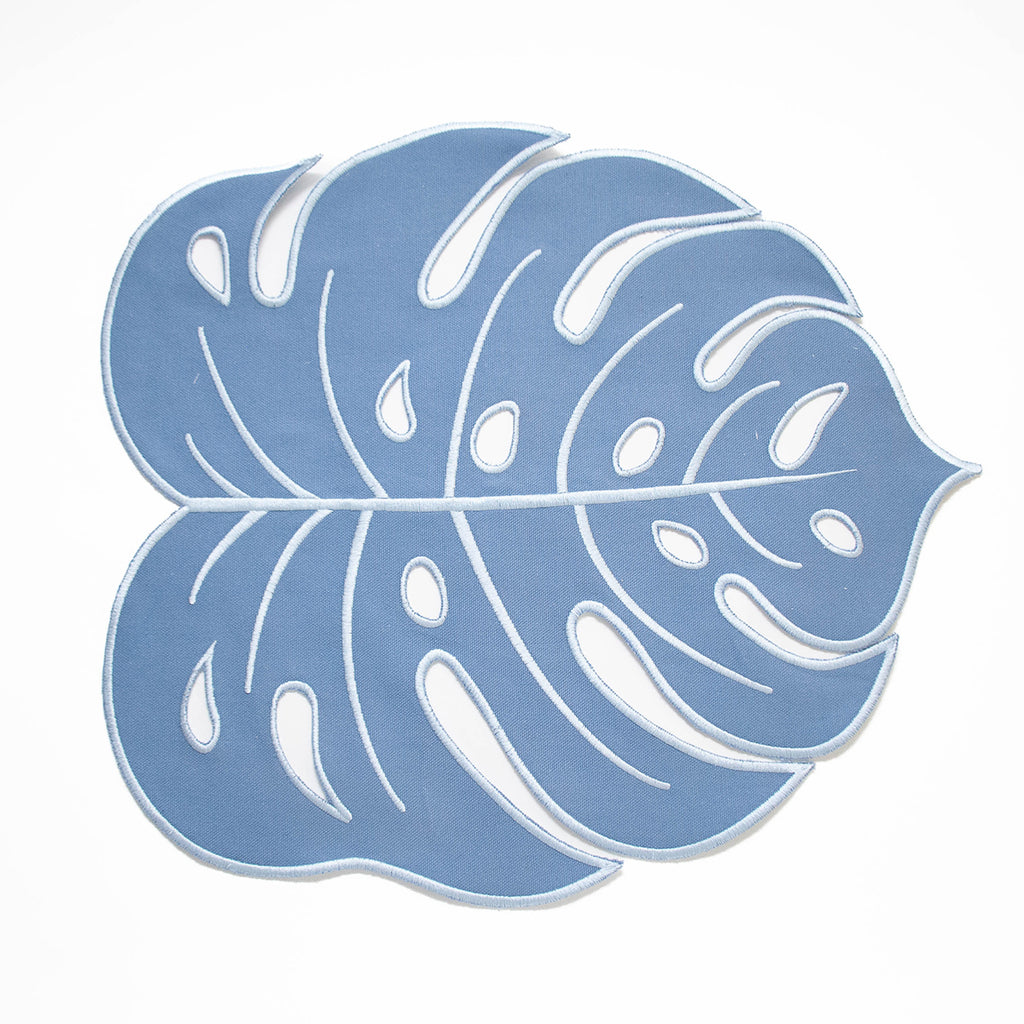 Mantel individual tropic en forma de hoja azul claro en loneta con orilla bordada. Perfecta para mesas tropicales, de jardín, terraza o verano