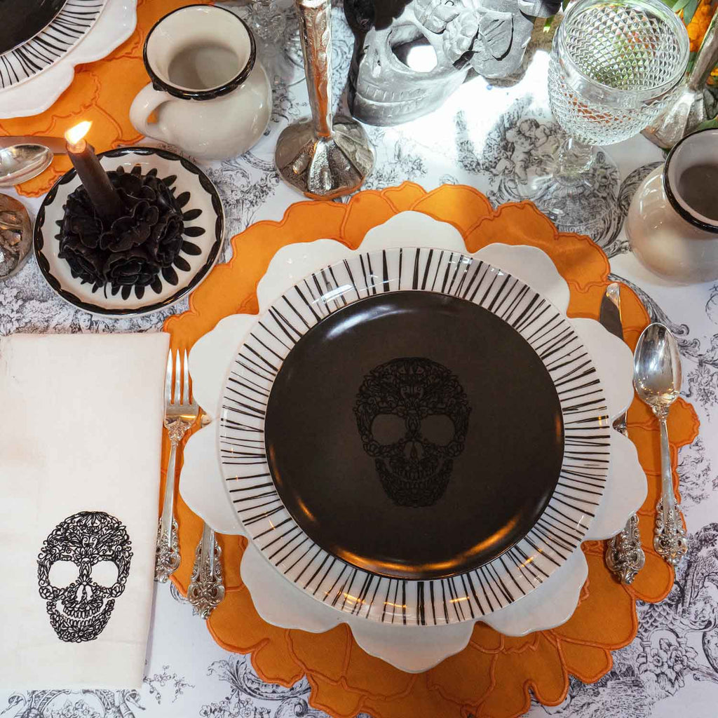 OFRENDA ZASHPACK: Set de Individuales en Forma de Cempasúchil en Loneta Naranja, Servilletas en Lino con Calaca Bordada en Negro, Platos Trinche de Rayas Negras y Platos para Ensalada Negros con Calaca. Set para 4 personas