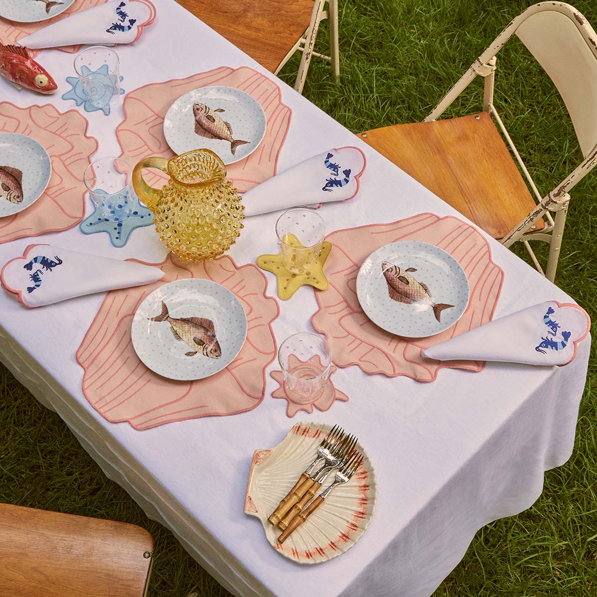 Mesa de playa o para servir mariscos con mantelería y vajilla en temas marinos, marca Zash