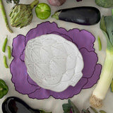 THE WHITE ARTICHOKE ZASHPACK: Set con 4 Servilletas Veggies en Algodón Morado Bordadas con Verduras y 4 Platos para Ensalada en Forma de Alcachofa Blanca de Bodallo Pinheiro.