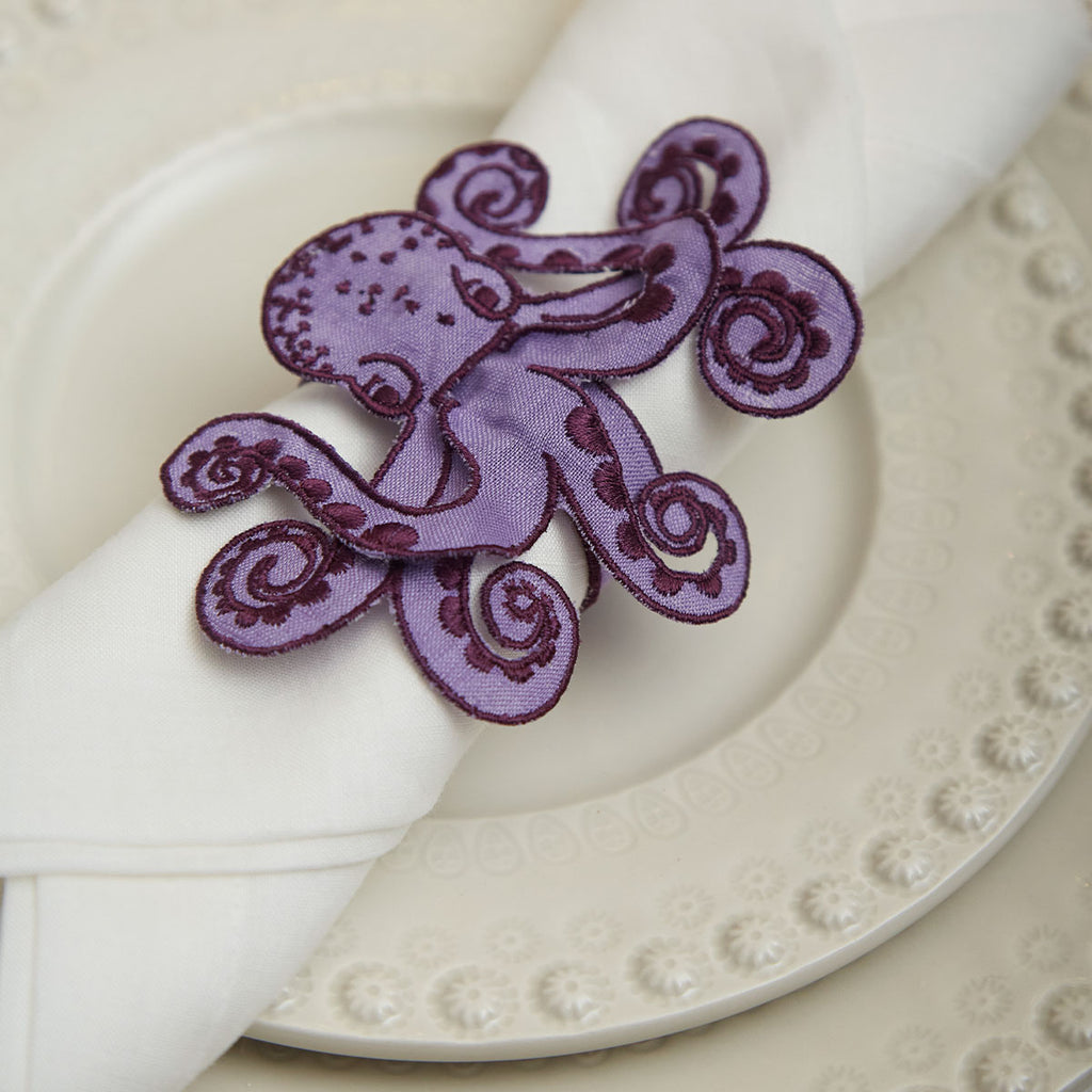 THE OCTOPUS ZASHPACK: Mantelería La Mar con Servilletas de Lino con Bordado de Coral Negro y Servilleteros con Bordado de Pulpo en Lino Morado. Set para 4 personas