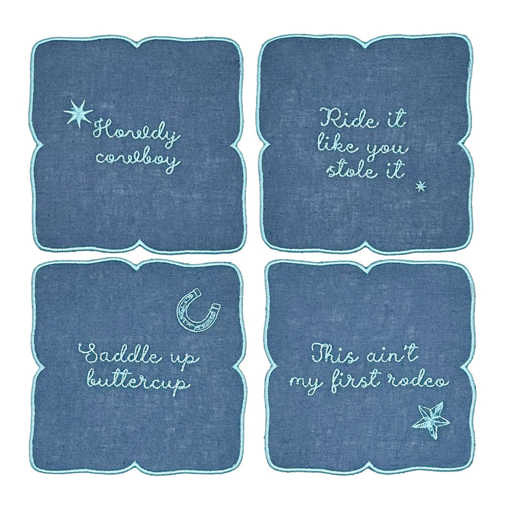 Servilletas cocteleras en lino azul rey con frases vaqueras bordadas en azul turquesa, marca Zash