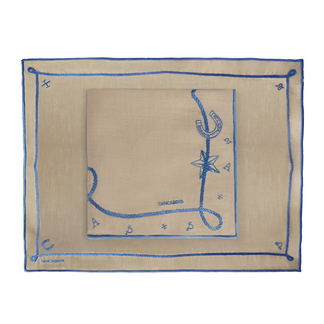 Set de Mantelería Cowgirl con individuales y servilletas en lino caramel con motivos vaqueros bordados en azul, diseñados por Dancassab para Zash