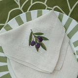 Mantelería Olivos con Individuales Blossom Bordado en Algodón Verde Olivo y Servilletas con Bordado de Aceitunas en Lino Arena. Set para 4 personas