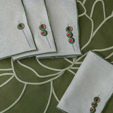 Mantelería Olivos con Individuales Blossom Bordado en Algodón Verde Olivo y Servilletas con Bordado de Aceitunas en Lino Arena. Set para 4 personas
