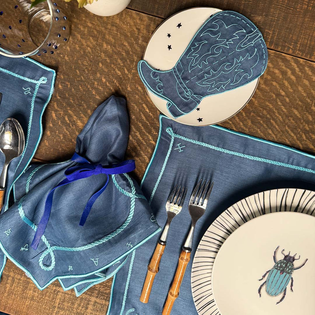 Mantelería Cowgirl con Individuales y Servilletas en Lino Azul con Bordado Teal. Set para 4 personas.