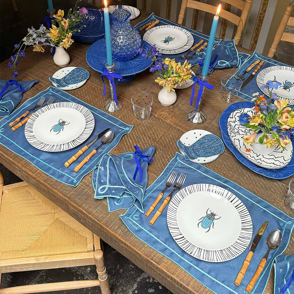 Mantelería Cowgirl con Individuales y Servilletas en Lino Azul con Bordado Teal. Set para 4 personas.