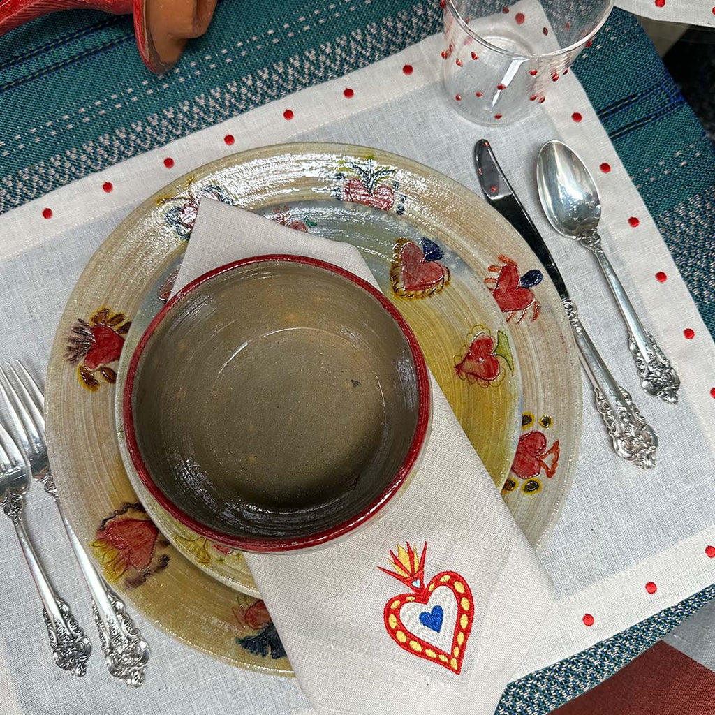 Mantelería Milagritos con Individuales Silvia con Puntitos Rojos y Servilletas Milagritos con Bordado de Corazón en llamas en Lino Arena. Set para 4 personas.