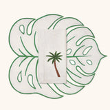 Individual de Hoja Tropic Arena con Orilla Verde y Servilletas con Bordado de Palmera. Set de 4