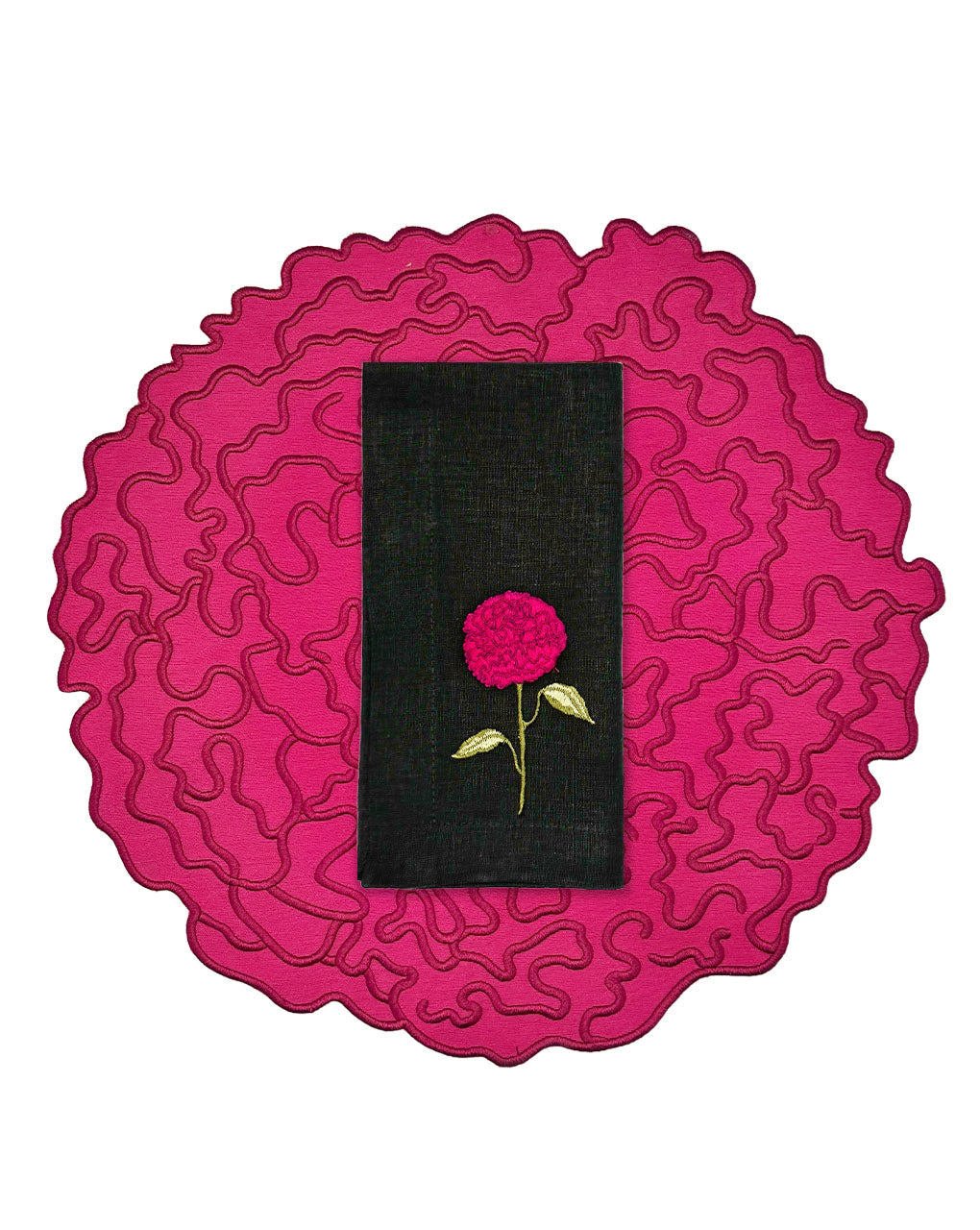 Set de mantelería de Flor de Celosía con individual en forma de flor en fuscia, y servilleta de lino negro con flor bordada, marca Zash