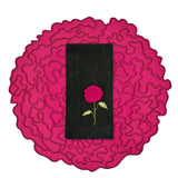 Set de mantelería de Flor de Celosía con individual en forma de flor en fuscia, y servilleta de lino negro con flor bordada, marca Zash