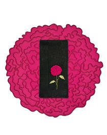Set de mantelería de Flor de Celosía con individual en forma de flor en fuscia, y servilleta de lino negro con flor bordada, marca Zash