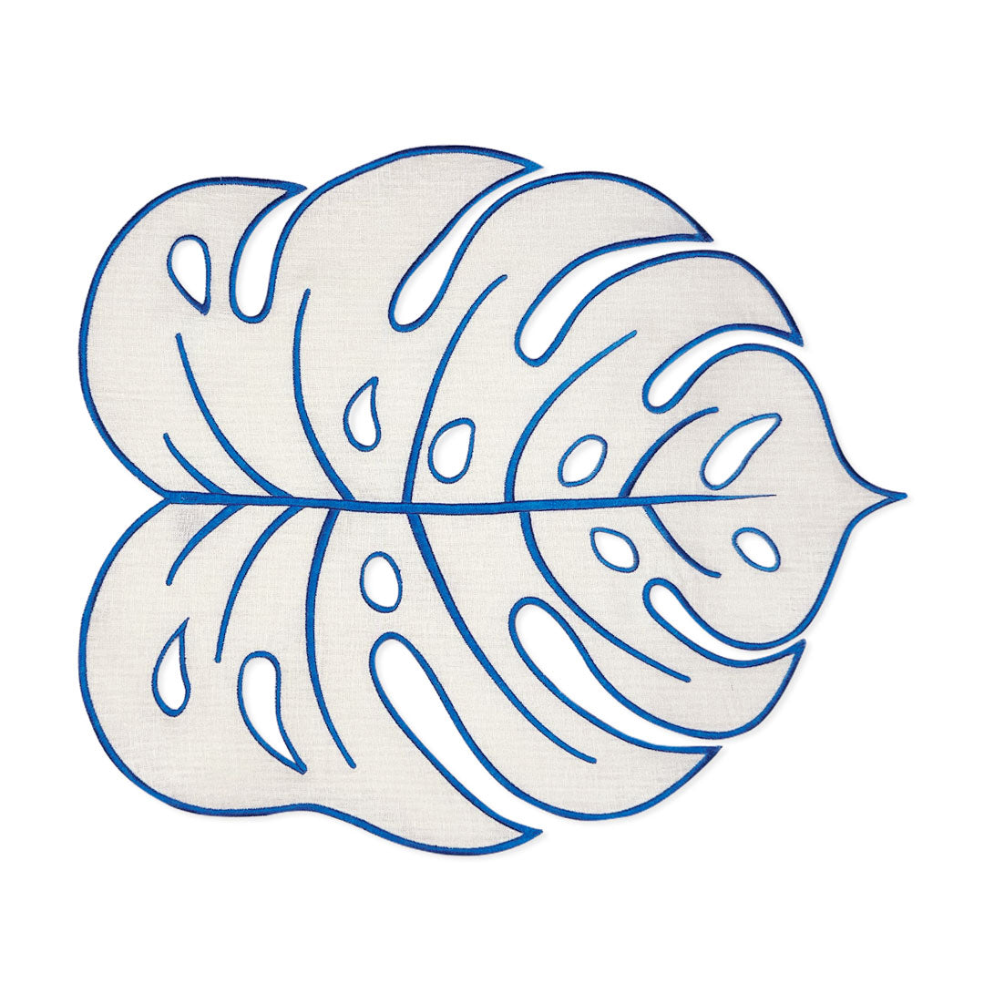 Mantel individual Tropic en lino arena en forma de hoja Monstera con orilla bordada en azul, marca Zash