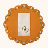 Mantelería Easter con Individual Pily en Algodón Naranja con Bordado de Florecitas y Servilleta Easter en Lino Ivory con Bordado de Conejo . Set de 4