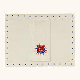 Mantelería Milagritos con Individuales Silvia con Puntitos Azules y Servilletas con Bordado de Corazón con Resplandor Azul en Lino Arena. Set para 4 personas