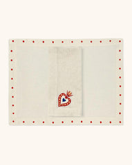 Mantelería Milagritos con Individuales Silvia con Puntitos Rojos y Servilletas Milagritos con Bordado de Corazón en llamas en Lino Arena. Set para 4 personas.
