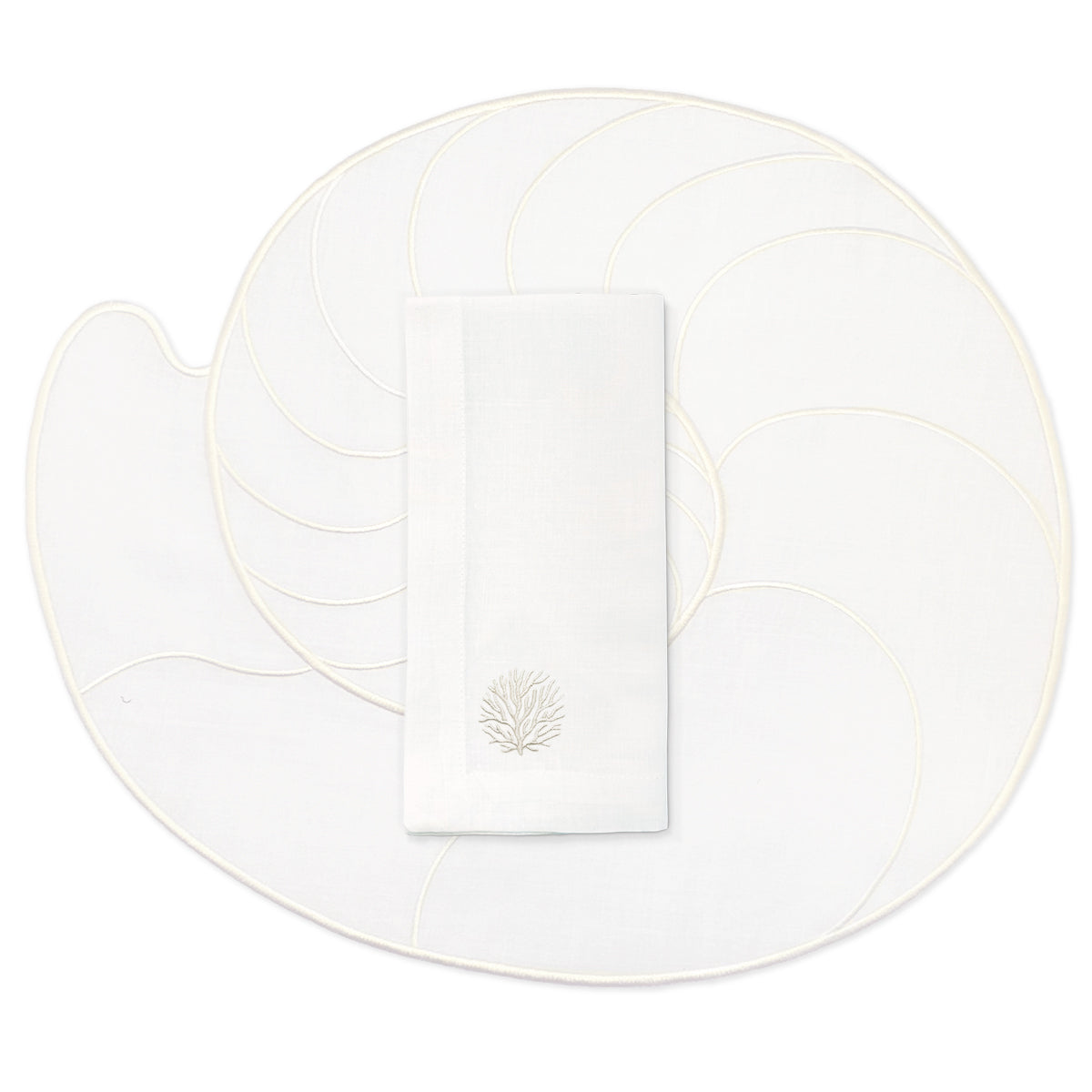 Set de mantelería de mar en lino blanco con individuales en forma de caracol de mar nautilus, y servilletas con bordado de coral en ivory, marca Zash