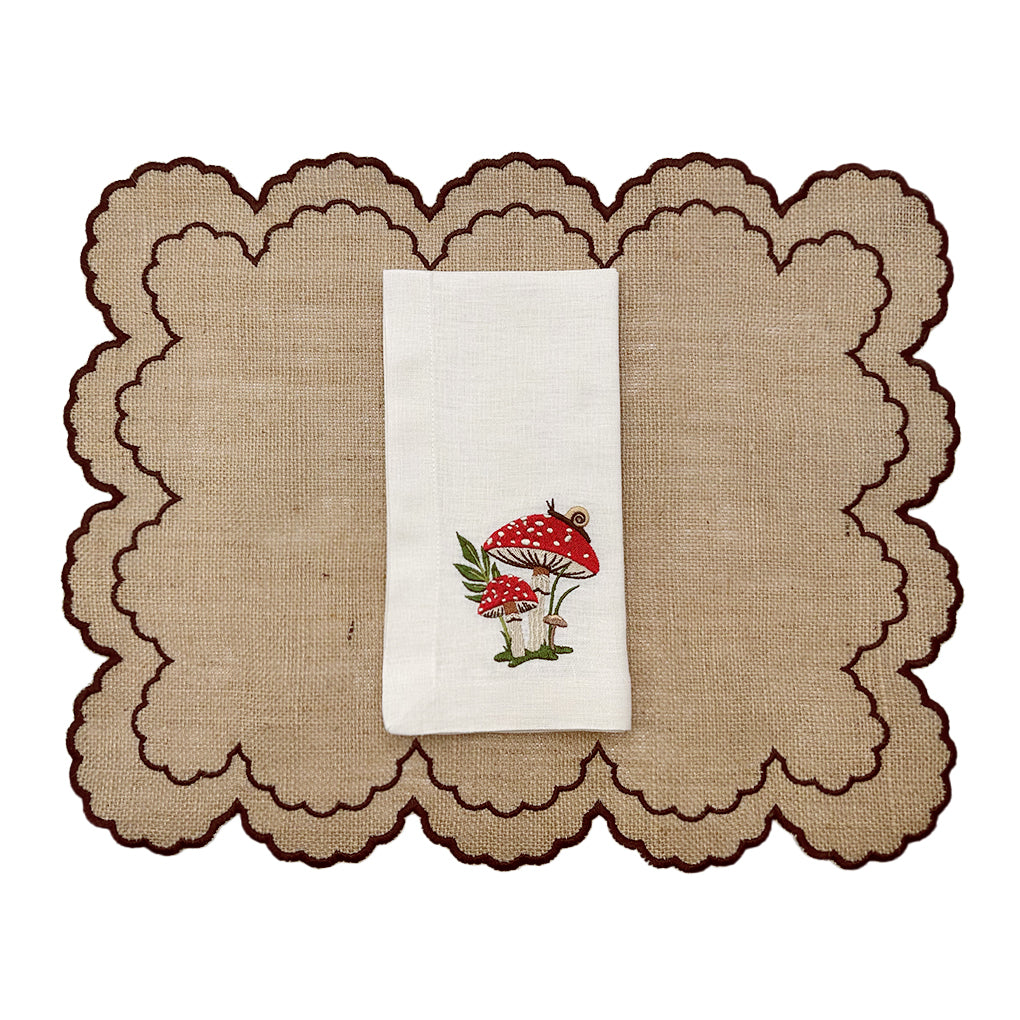 Set de individuales de yute Majo con orilla bordada en ondas café con servilletas de lino crudo con bordado de hongos y caracol