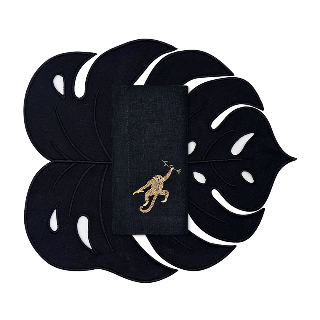 Set de mantelería Tropic en lino negro con individual en forma de hoja monstera y servilleta con chango bordado