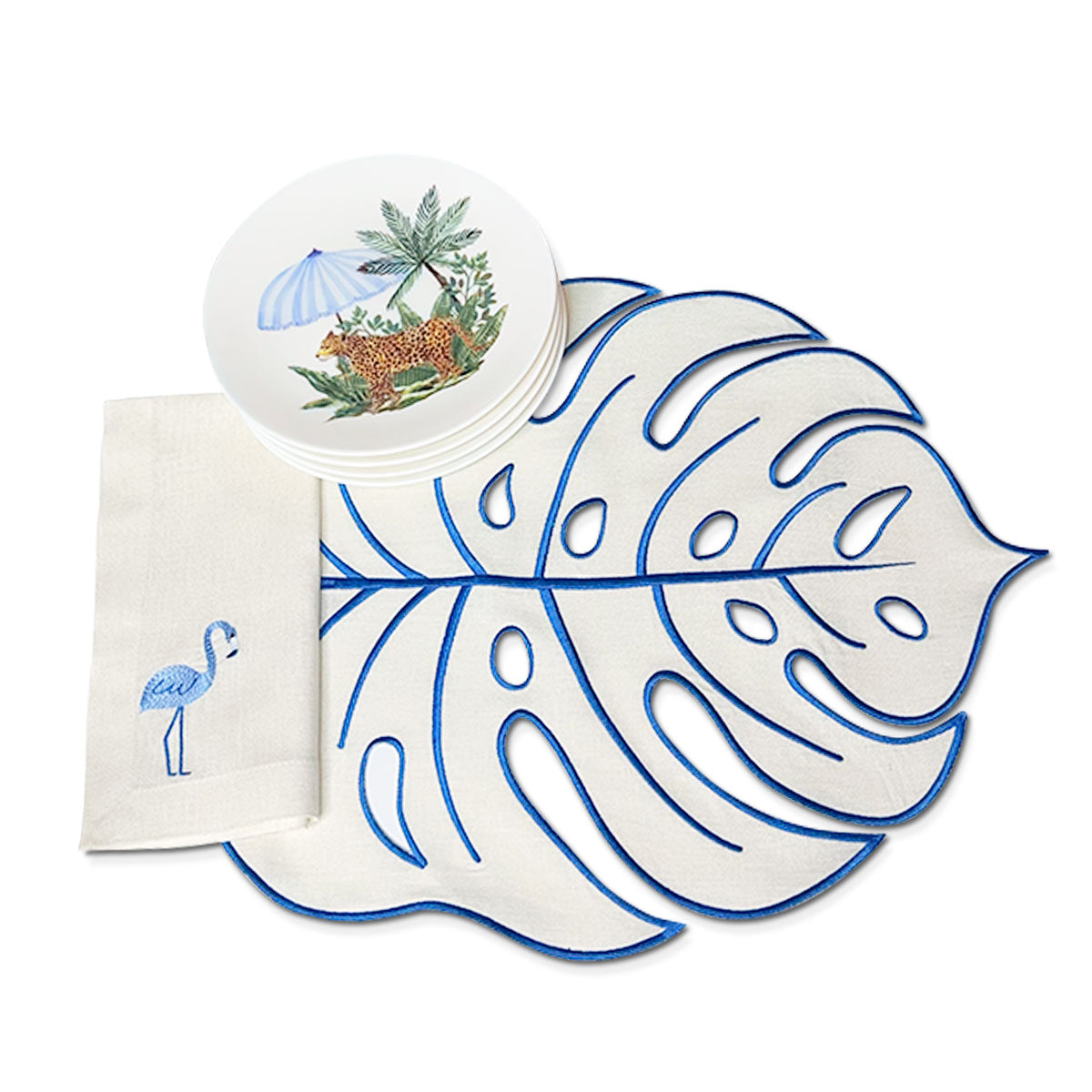 Set de mesa Tropical con mantelería tropic en lino arena con bordado en azul y platos de ensalada de leopardo con sombrilla, marca Zash