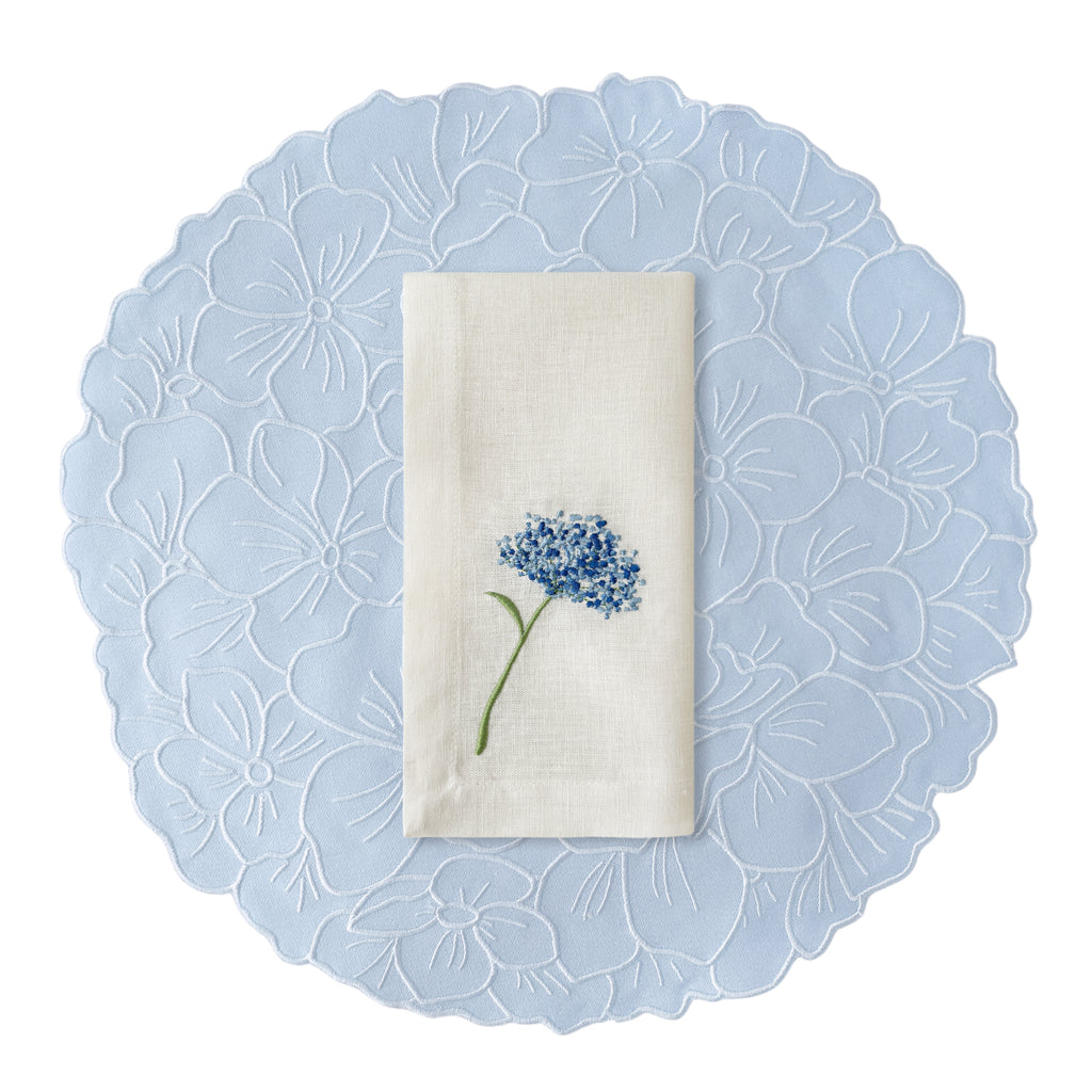 Set de manteles individuales en forma de flor hortensia azul, con servilletas de lino blanco bordada con flor azul, marca Zash