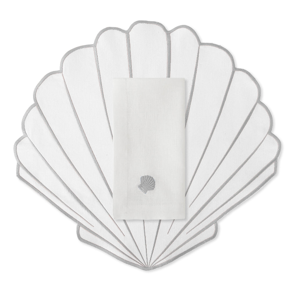 Set de Mantelería con Individuales en forma de Concha de Mar en blanco con orilla bordada en Gris, con Servilleta de Lino Blanco con Conchita gris, marca Zash