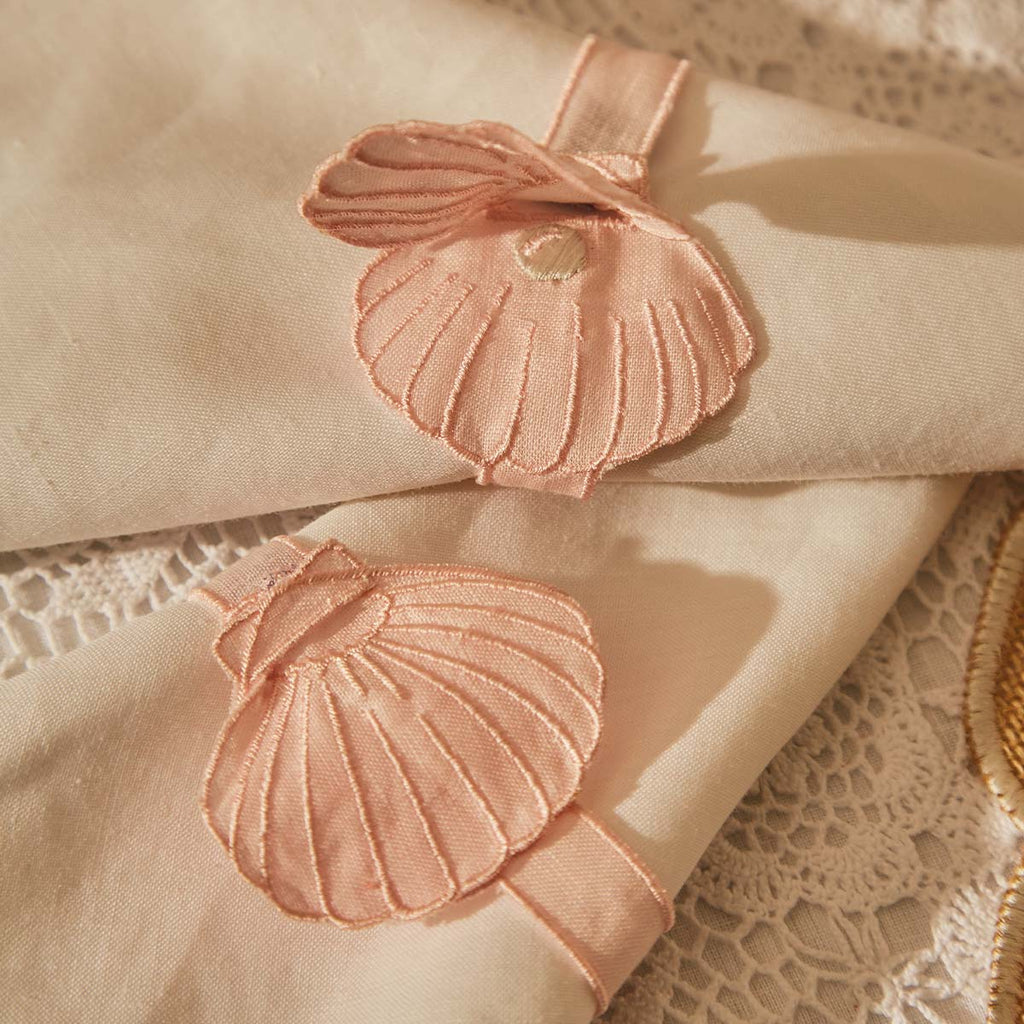 THE PEARL ZASHPACK: Mantelería La Mar con Individuales Concha en Yute, Servilletas de Lino con Bordado de Caracol de Mar y Servilleteros con Bordado de Ostra en Lino Rosa. Set para 4 personas