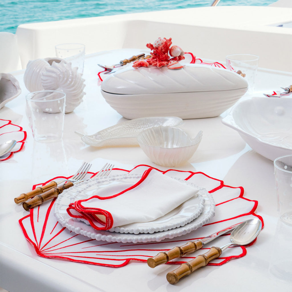 Set Mantelería Concha en Rojo: 4 Individuales en Forma de Concha con 4 Servilletas con Orilla Bordada en Rojo.