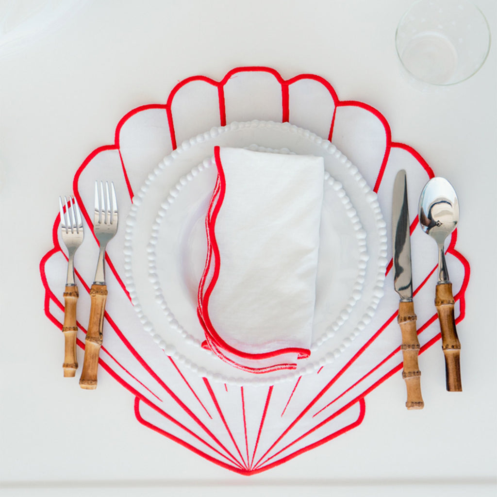 Set Mantelería Concha en Rojo: 4 Individuales en Forma de Concha con 4 Servilletas con Orilla Bordada en Rojo.