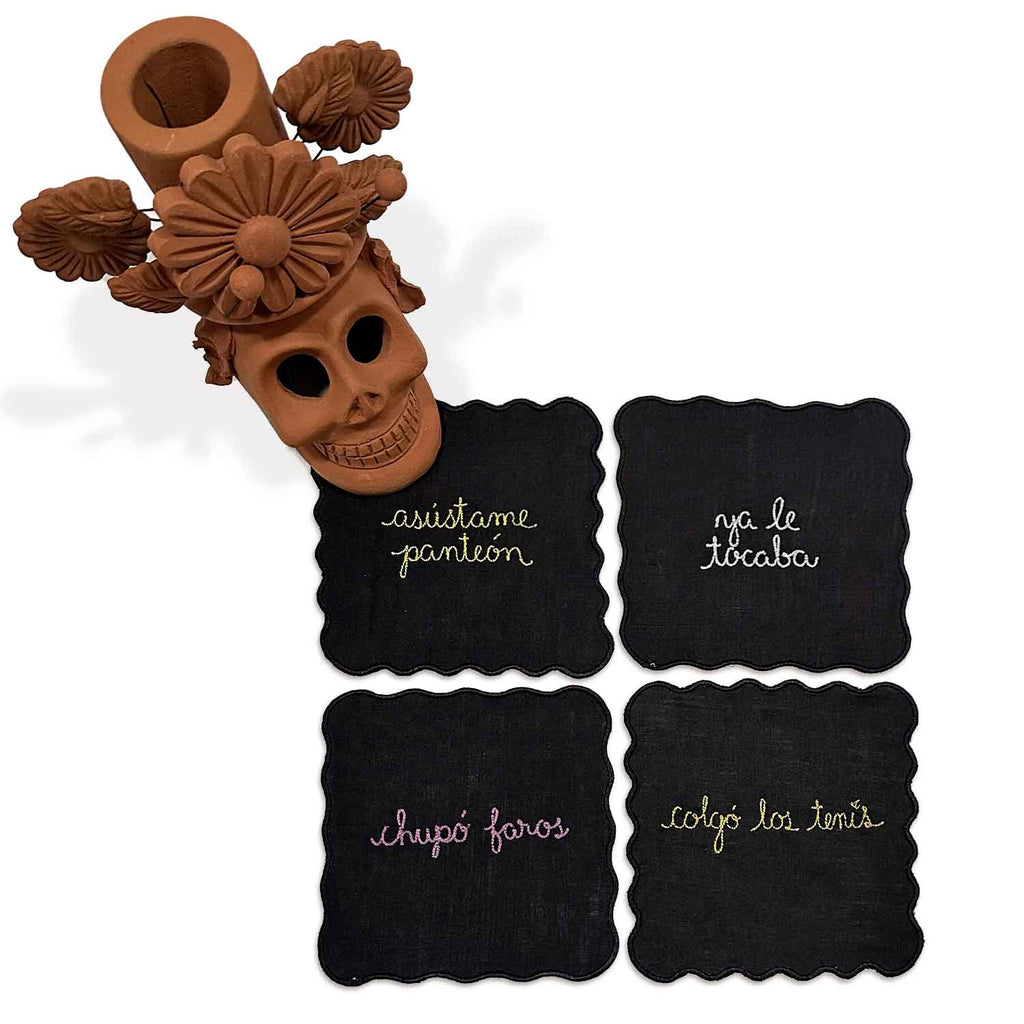 Setting de Muertos con servilletas cocteleras con frases de muertos y candelabro de barro con Calaca, marca Zash