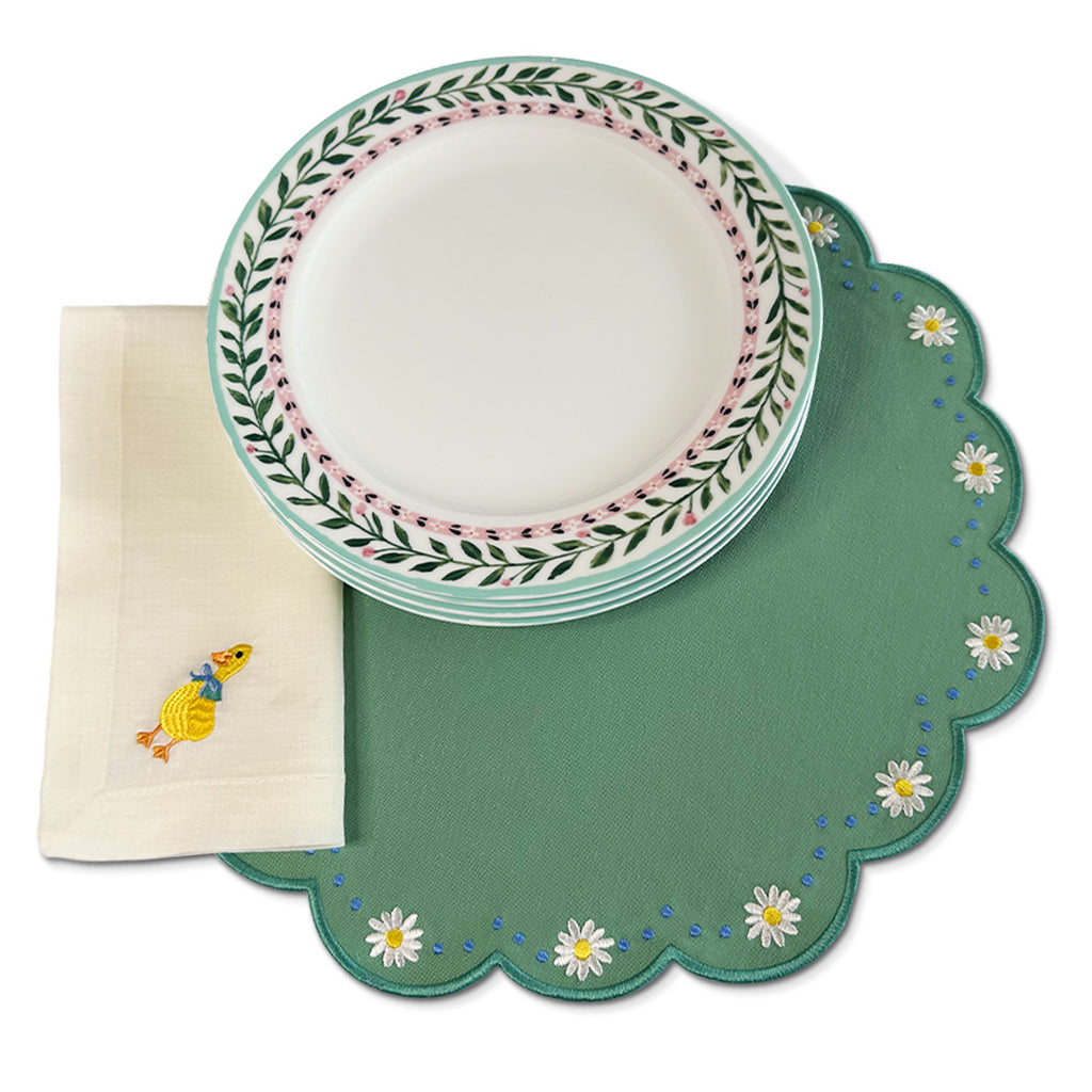 Set de mesa con individuales Pily en verde menta con flores bordadas, servilleta de lino ivory con bordado de patito y platos trinche con borde de flores, marca Zash