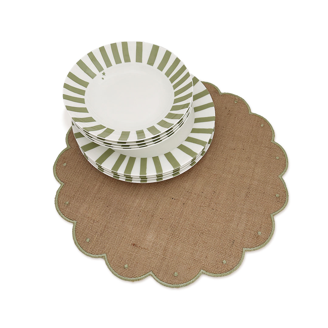 Un setting de mesa con mantelería de yute natural y vajilla con rayas verde olivo, marca Zash
