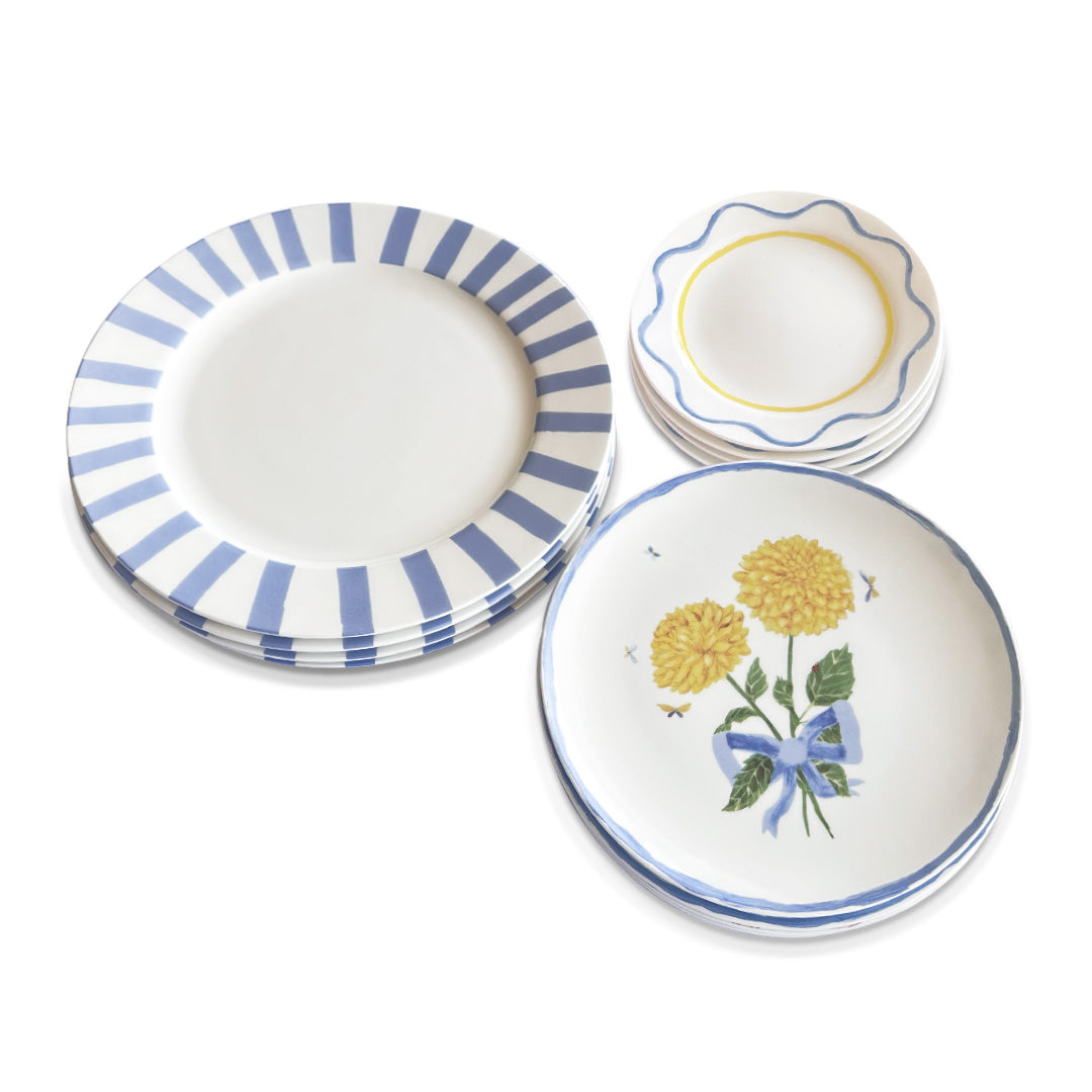 Set de vajilla Blue Flower de porcelana con platos trinche con rayas azules, platos de ensalada con Dalias Amarillas y listón azul, y platos de pan con ondas azul y amarillo, marca Zash