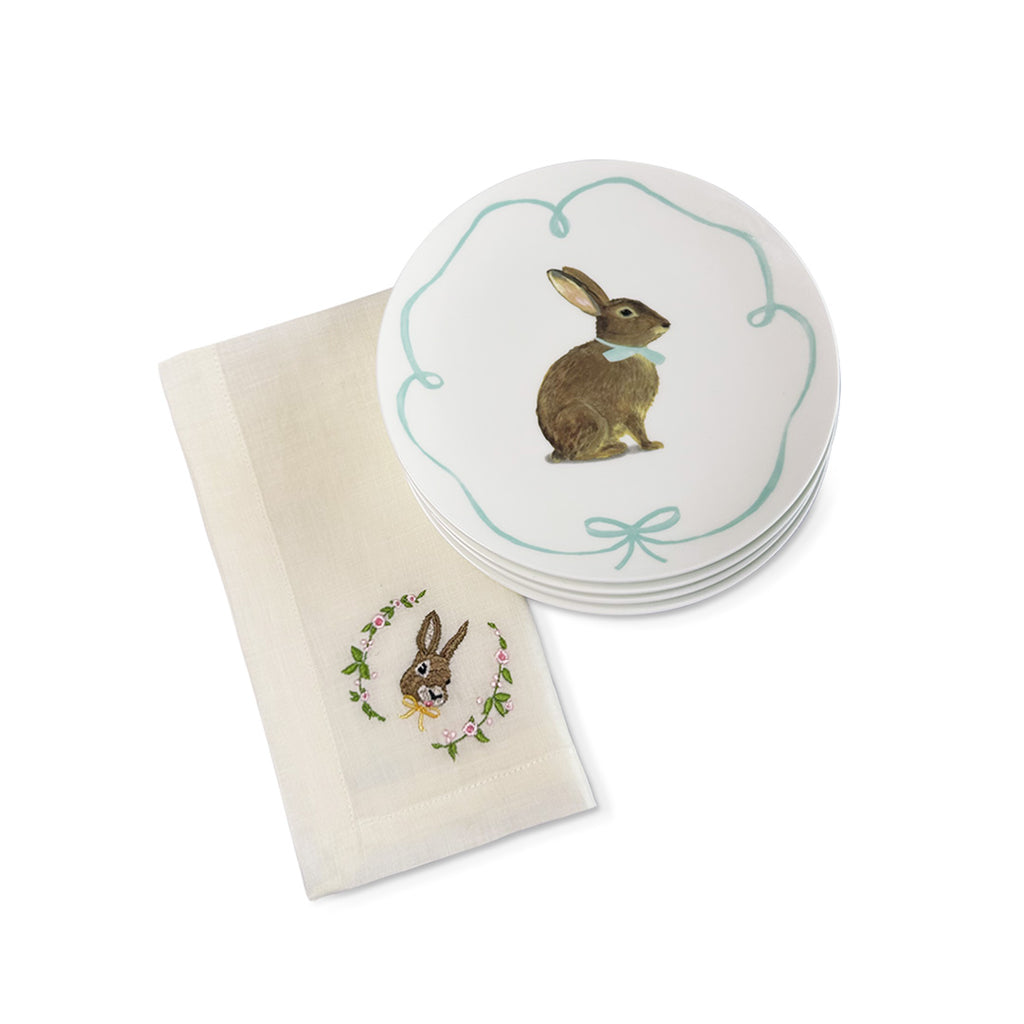 Set para mesa de Pascua con Platos de Ensalada blancos con ilustración de conejito con moño y servilletas de lino Ivory con bordado de conejo con moño y flores, marca Zash