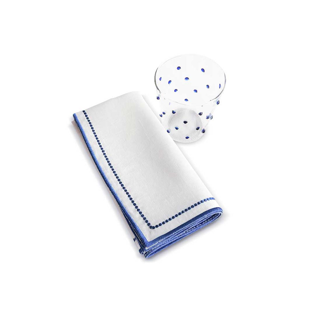 Zashpack que incluye vasos con puntitos azules y servilletas de lino blanco con doble orilla bordada en azul, marca Zash